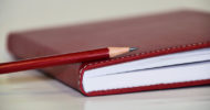 agenda di colore rosso con matita rossa