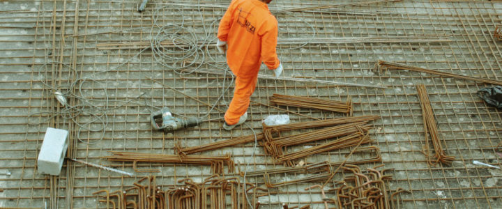 cantiere di un palazzo lavoratore con elmetto e abbigliamento da cantiere