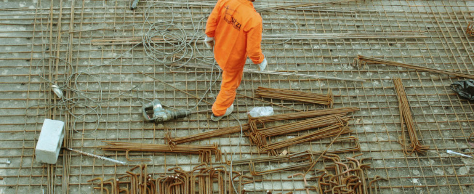 cantiere di un palazzo lavoratore con elmetto e abbigliamento da cantiere