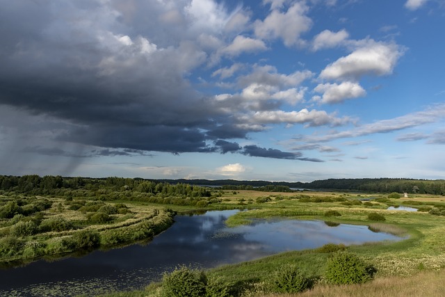 campagna con fiume che scorre attraverso i prati cielo parzialmente nuvoloso