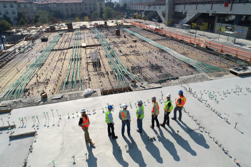 palazzo in costruzione con un gruppo di progettisti che guardano il cantiere