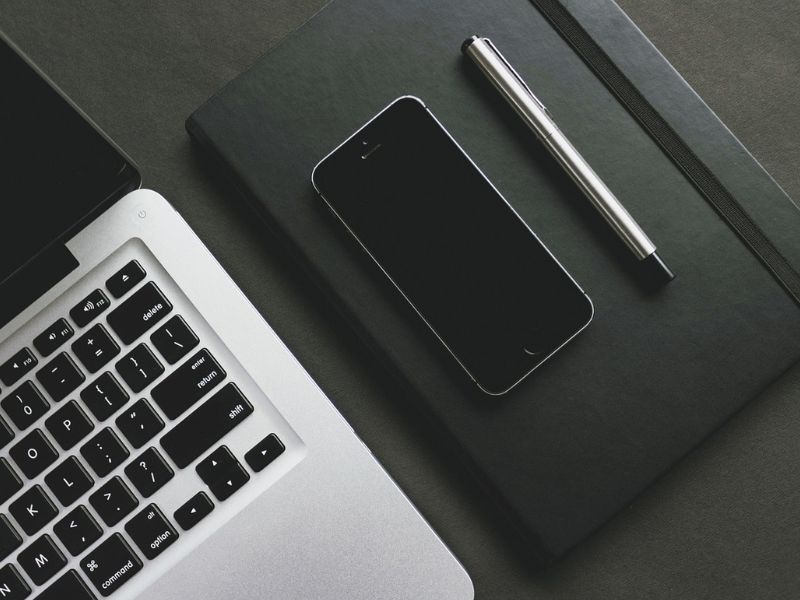 un computer, un telefonino e una penna sulla scrivania